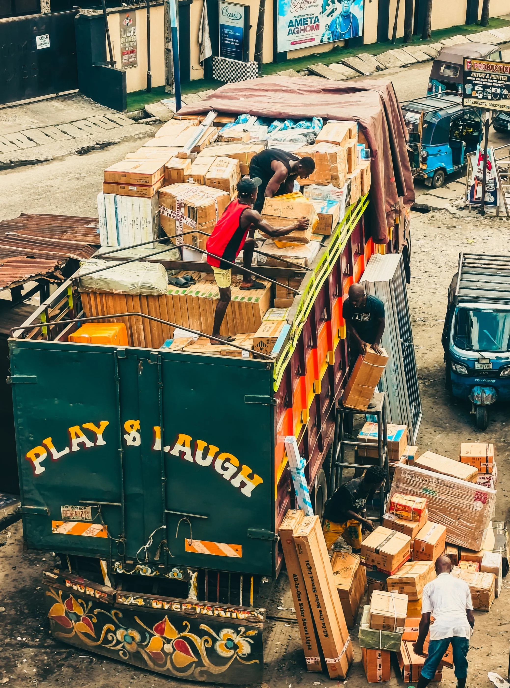 Workers in Lagos load cartons onto a brightly painted cargo truck